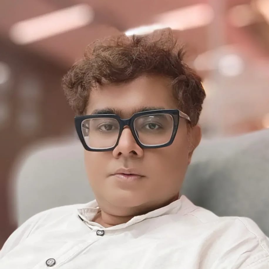 Person wearing glasses and a white shirt with a blurred background